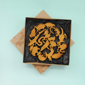 A round wooden Australian animal design trivet in a recycled card presentation box