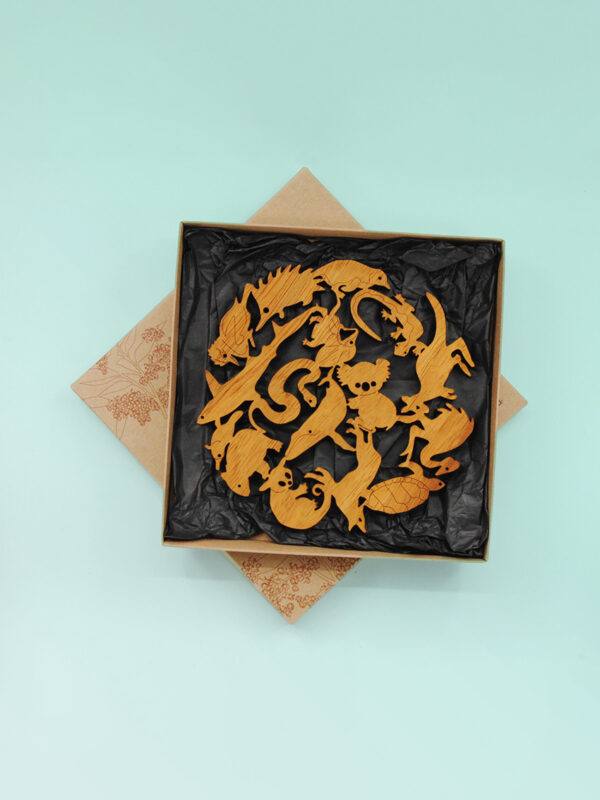 A round wooden Australian animal design trivet in a recycled card presentation box