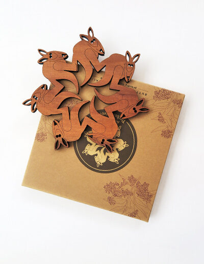 A round wooden kangaroo design trivet in a recycled card presentation box