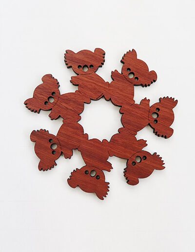 A round wooden koala design trivet