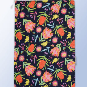A fabric travel laundry bag with Aussie Flora pattern on it and a zip closure.