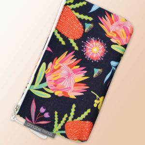 Small water resistant cosmetic bag with an Aussie Flora pattern on it and a zip closure.