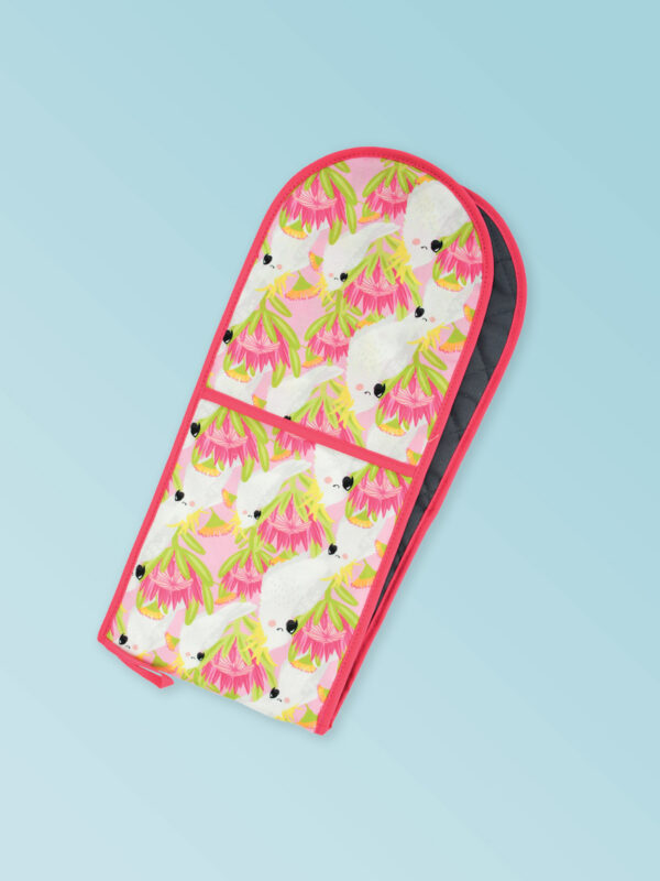 Insulated double oven mitts with a pink cockatoo pattern on the fabric and a dark pink edging..