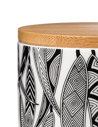 A close up detail of a Ceramic sugar bowl with a bamboo lid. The sugar bowl has artwork by Mick Harding on it. It is black and white.