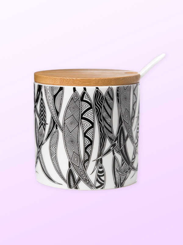 Ceramic sugar bowl with a ceramic spoon and a bamboo lid. The sugar bowl has artwork by Mick Harding on it. It is black and white.