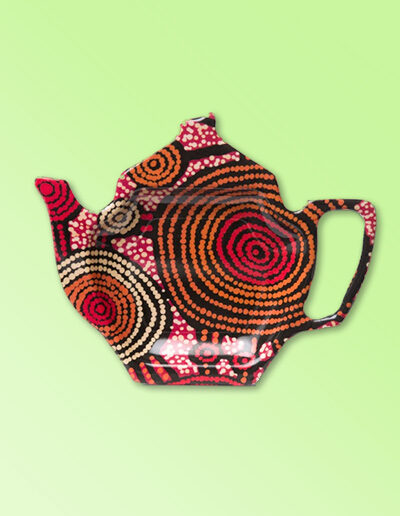 Melamine tea bag holder in the shape of a teapot. The pattern on it is artwork by Teddy Gibson