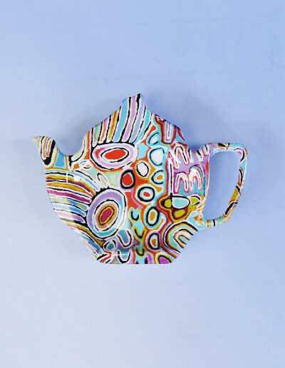 Melamine tea bag holder in the shape of a teapot. The pattern on it is artwork by Judy Watson