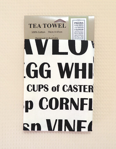 A white cotton tea towel with a Pavlova recipe printed in black on it.