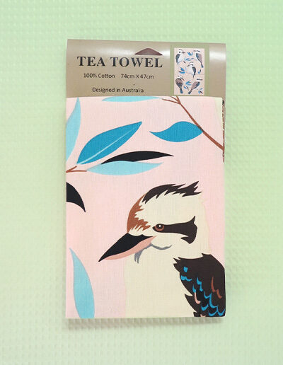 A light pink cotton tea towel with Kookaburra images printed on it.