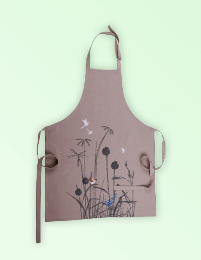 A Kitchen apron with an embroidered pair of blue wrens perched in grasses as the fabric design. The fabric is a natural Australian organic cotton. The neck strap is adjustable and the waist ties are generous.
