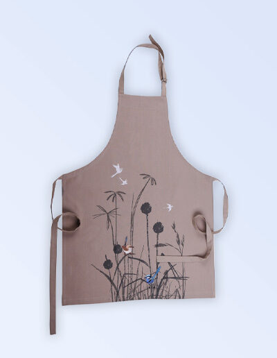 A Kitchen apron with an embroidered pair of blue wrens perched in grasses as the fabric design. The fabric is a natural Australian organic cotton. The neck strap is adjustable and the waist ties are generous.