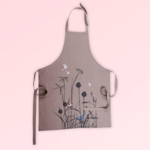 A Kitchen apron with an embroidered pair of blue wrens perched in grasses as the fabric design. The fabric is a natural Australian organic cotton. The neck strap is adjustable and the waist ties are generous.