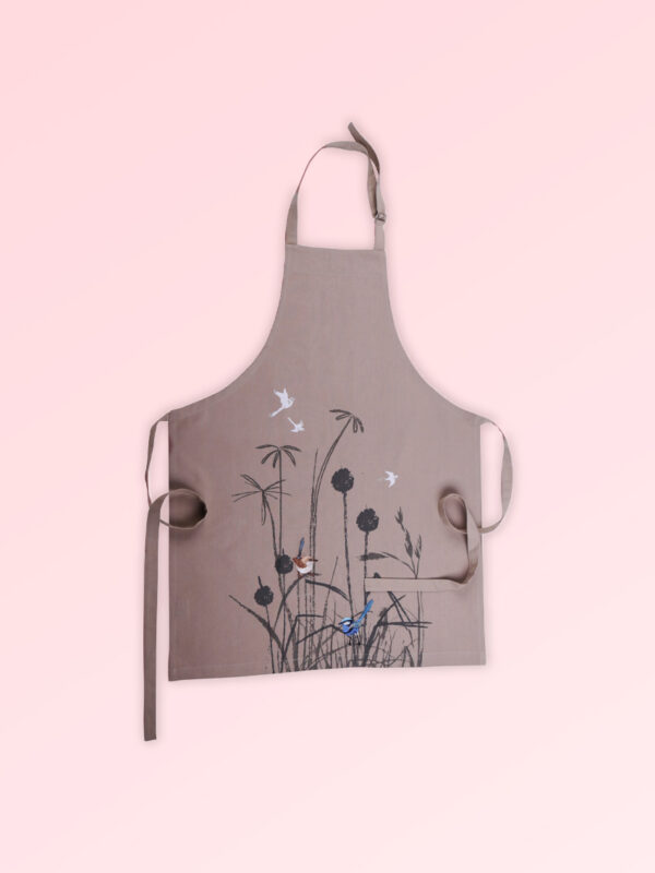 A Kitchen apron with an embroidered pair of blue wrens perched in grasses as the fabric design. The fabric is a natural Australian organic cotton. The neck strap is adjustable and the waist ties are generous.