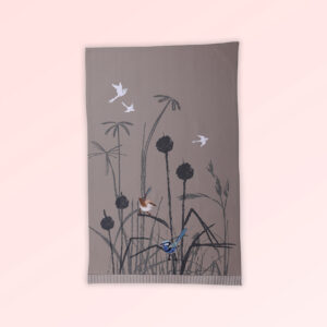 Tea towel with an embroidered pair of blue wrens perched in grasses. The fabric is a natural Australian organic cotton.