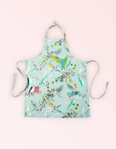 Kitchen apron with adjustable neck strap. The fabric is Australian organic cotton with an aqua background and budgerigars and small native flowers in pastel colours. The neck strap and waist straps are a soft grey.