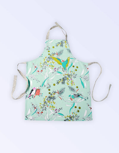 Kitchen apron with adjustable neck strap. The fabric is Australian organic cotton with an aqua background and budgerigars and small native flowers in pastel colours. The neck strap and waist straps are a soft grey.