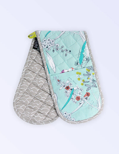 Insulated double oven mitts. The fabric is Australian organic cotton with an aqua background and budgerigars and small native flowers in pastel colours. The trim around it is soft grey with a tab for hanging.