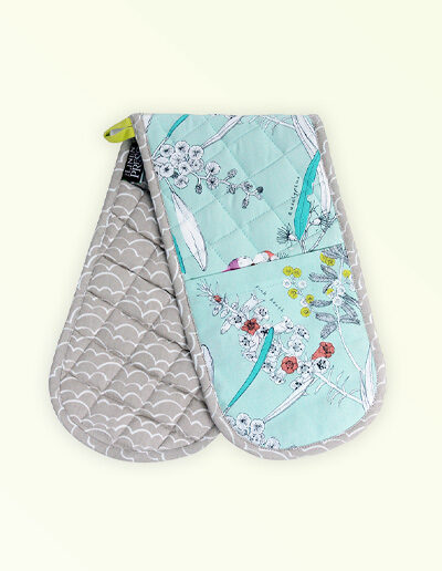 Insulated double oven mitts. The fabric is Australian organic cotton with an aqua background and budgerigars and small native flowers in pastel colours. The trim around it is soft grey with a tab for hanging.