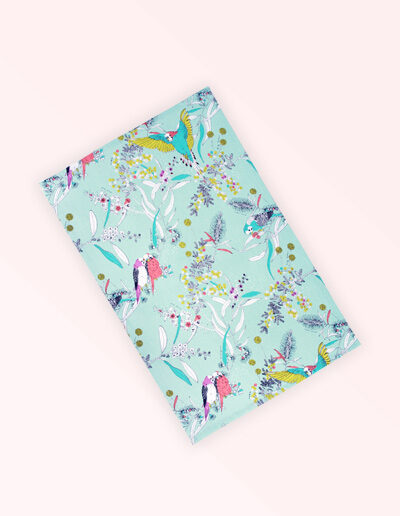 Tea towel with an aqua background and budgerigars and small native flowers in pastel colours. The fabric is a natural Australian organic cotton.