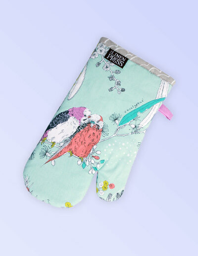 Single insulated oven mitt. The fabric is Australian organic cotton with an aqua background and budgerigars and small native flowers in pastel colours. The trim around it is soft grey with a tab for hanging.