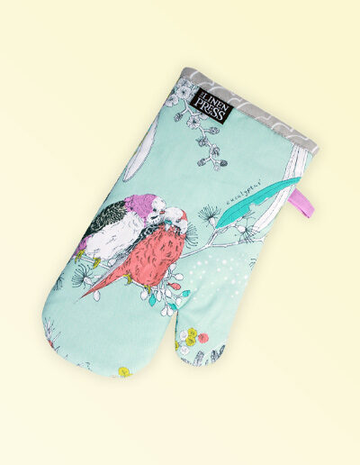 Single insulated oven mitt. The fabric is Australian organic cotton with an aqua background and budgerigars and small native flowers in pastel colours. The trim around it is soft grey with a tab for hanging.