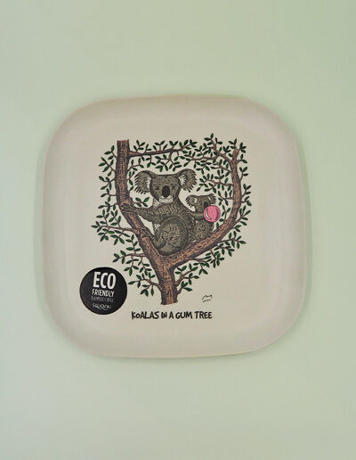 An eco friendly bamboo plate with a whimsical illustration of a koala in a gum tree on it.