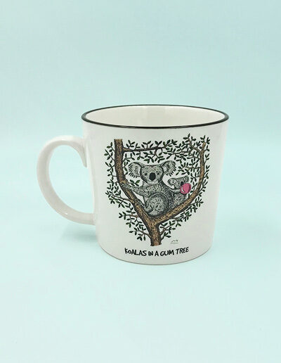 A porcelain mug with a whimsical illustration of a koala in a gum tree on it.