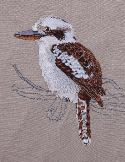 Close up image of an embroidered Kookaburra on the natural Australian organic cotton fabric