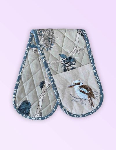 Double oven mitt, insulated. This double oven mitt is made with organic cotton featuring an embroidered Kookaburra. The oven mitt fabric is a natural cotton colour with screen printed banksia design in blue grey and beige. The edge is trimmed with a blue grey cotton fabric.