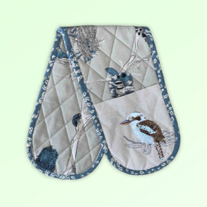 Double oven mitt, insulated. This double oven mitt is made with organic cotton featuring an embroidered Kookaburra. The oven mitt fabric is a natural cotton colour with screen printed banksia design in blue grey and beige. The edge is trimmed with a blue grey cotton fabric.