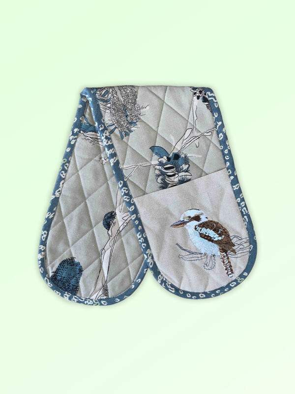 Double oven mitt, insulated. This double oven mitt is made with organic cotton featuring an embroidered Kookaburra. The oven mitt fabric is a natural cotton colour with screen printed banksia design in blue grey and beige. The edge is trimmed with a blue grey cotton fabric.