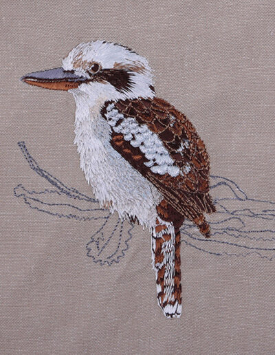 Close up image of an embroidered Kookaburra on the natural Australian organic cotton fabric