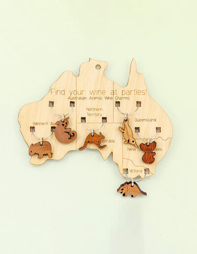 Wooden map of Australia which presents on it 6 wine glass charms of six different animals. One is attached to the map in each state.