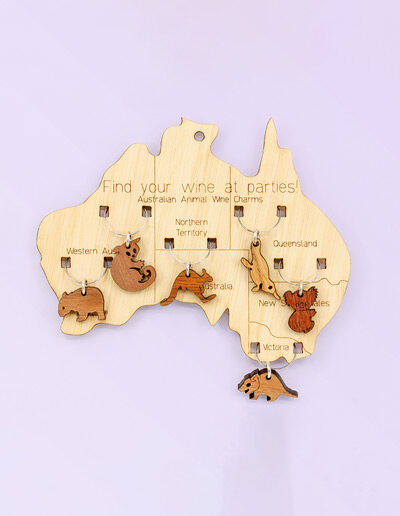 Wooden map of Australia which presents on it 6 wine glass charms of six different animals. One is attached to the map in each state.