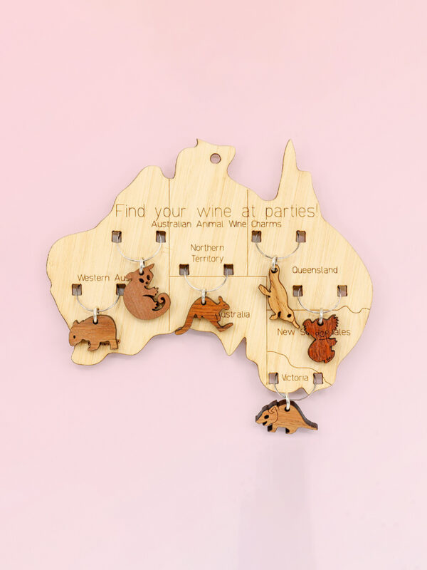 Wooden map of Australia which presents on it 6 wine glass charms of six different animals. One is attached to the map in each state.