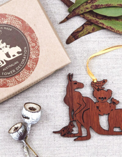 A wooden decoration featuring Australian animals. It is next to its recycled cardboard box.