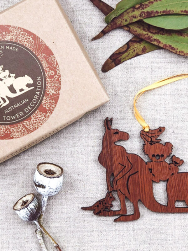 A wooden decoration featuring Australian animals. It is next to its recycled cardboard box.