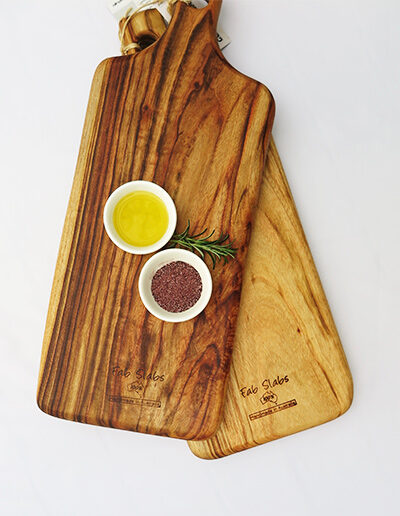Two large wooden paddle chopping boards with a dish of salt & a dish of oil