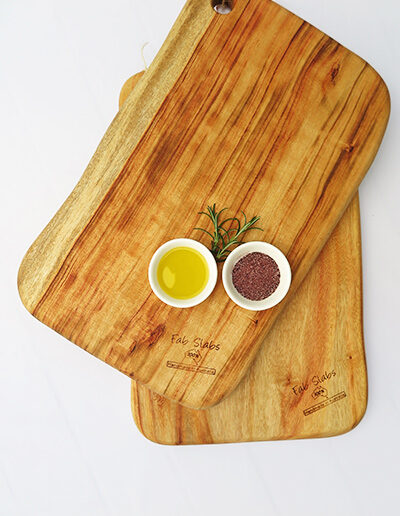 Two large wooden chopping boards with a dish of salt & a dish of oil