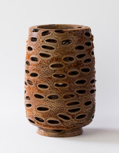 A tall tea light holder made out of a banksia seed pod.