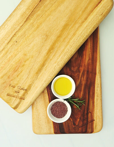 Two medium wooden chopping boards with a dish of salt & a dish of oil