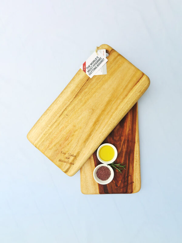 Two medium wooden chopping boards with a dish of salt & a dish of oil