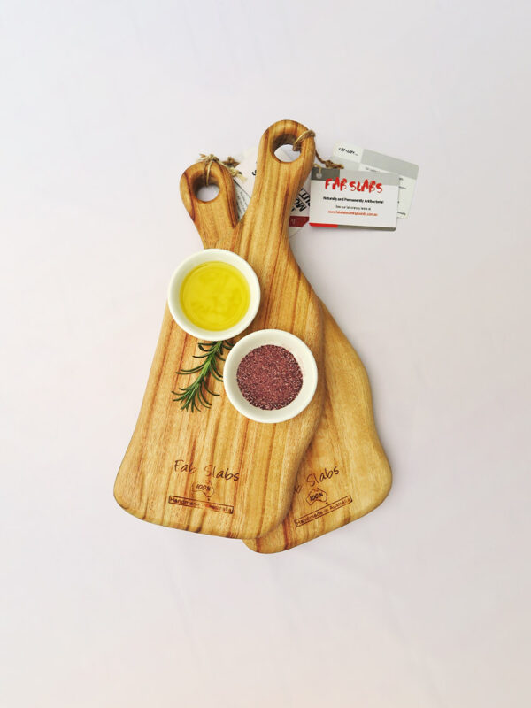 Two small paddle chopping boards with a dish of salt & a dish of oil